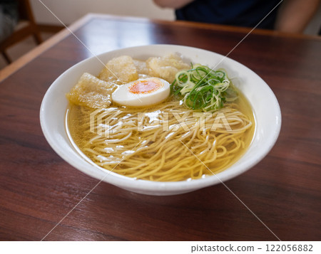 This salt ramen has a clear, golden soup and is topped with boiled egg, green onion, and wheat gluten. This salt ramen has a clear, golden soup and is topped with boiled egg, green onion, and wheat gluten. 122056882