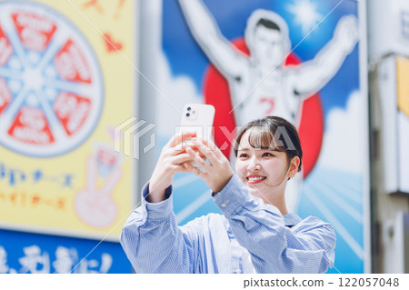 A young woman taking a selfie at Ebisubashi Bridge in Osaka 122057048