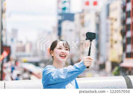 A young woman taking a selfie while sightseeing in Osaka A young woman taking a selfie while sightseeing in Osaka 122057050
