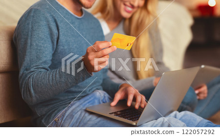 Online Shopping. Happy Couple Ordering On Laptop Paying With Credit Card Sitting On Floor Indoor. Selective Focus 122057292