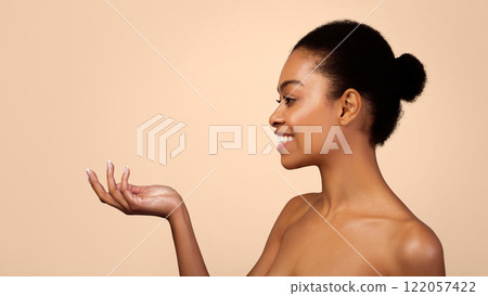 Skincare Product Advertisement. Happy Black Woman Holding Invisible Cosmetics Jar Or Bottle Advertising Product Looking Aside Over Gray Studio Background. Beauty Of Skin Concept. Panorama, Side View 122057422