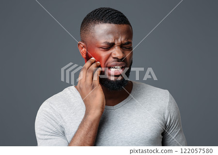 Sad afro man having gum problems, touching his cheek, white studio background, tooth disease concept Sad afro man having gum problems, touching his cheek, white studio background, tooth disease concept 122057580