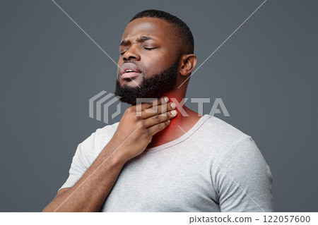 Sad black guy suffering from sore throat, touching highlighted neck, copy space 122057600
