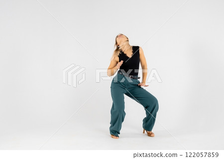 Young blonde dancer posing with hands joined and legs apart on white background Young blonde dancer posing with hands joined and legs apart on white background 122057859