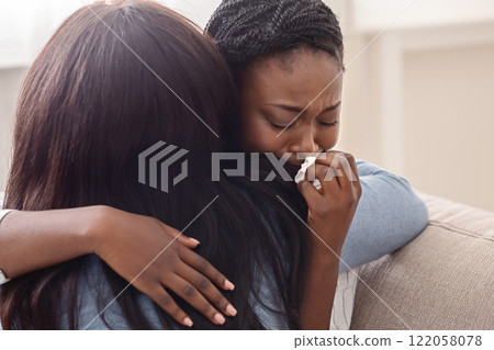 Condolence and support concept. Caring woman hugging her crying black girlfriend, comforting her after receiving bad news 122058078