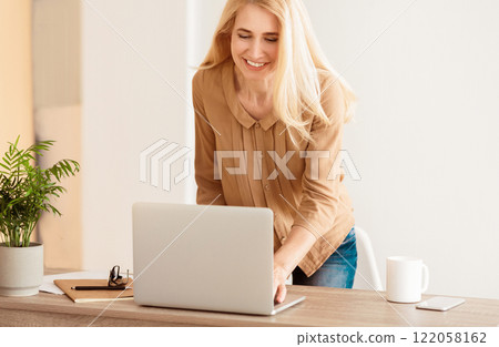 Responding On Business E-Mail. Woman Using Laptop, Standing In Office Responding On Business E-Mail. Woman Using Laptop, Standing In Office 122058162