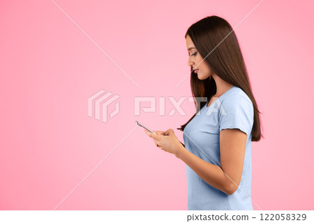 People, Technology And Communication Concept. Side view portrait of smiling woman chatting on her cellphone, isolated over yellow studio background, free space. Young woman using smartphone People, Technology And Communication Concept. Side view portrait of smiling woman chatting on her cellphone, isolated over yellow studio background, free space. Young woman using smartphone 122058329