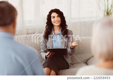 Successful Therapy. Professional latina psychologist consulting elderly spouses helping them restore marriage 122058455