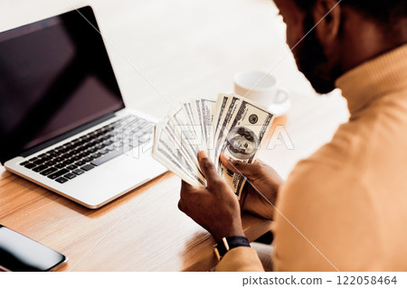 Business Concept. Unrecognizable black businessman counting money, US dollar bills. Rear view 122058464