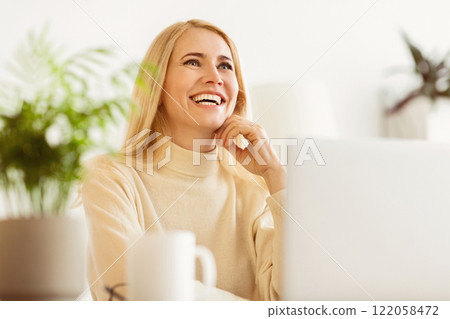 Happy Mature Woman Dreaming when Websurfing On Laptop At Home 122058472