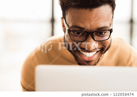 Happy African Businessman Making Video Call To Family Using Laptop During Rest Break At Work, Close-Up 122058474