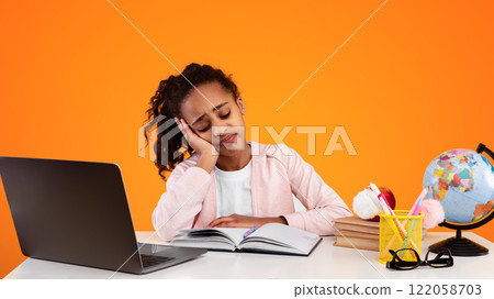 Education And Overworking Concept. Tired black female student studying at working table. Exhausted girl preparing for exams, reading paper book or her notes and falling asleep, resting head on hand Education And Overworking Concept. Tired black female student studying at working table. Exhausted girl preparing for exams, reading paper book or her notes and falling asleep, resting head on hand 122058703