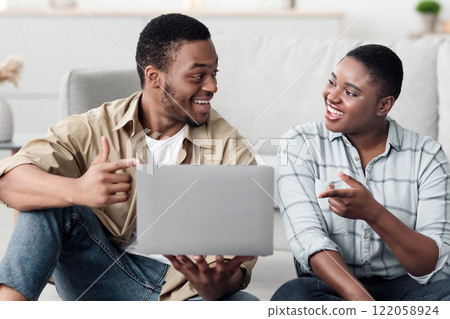 Family Vacation. African American Tourists Couple Using Laptop Booking Tickets Online Sitting On Sofa At Home. Spouses Planning Trip Browsing Internet On Computer Indoors. Selective Focus Family Vacation. African American Tourists Couple Using Laptop Booking Tickets Online Sitting On Sofa At Home. Spouses Planning Trip Browsing Internet On Computer Indoors. Selective Focus 122058924