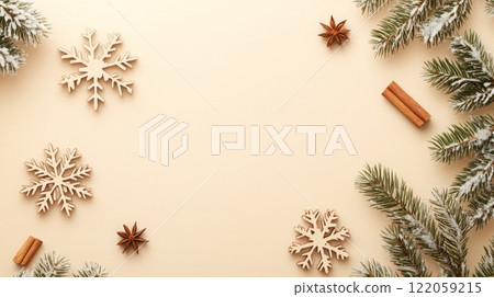 Wooden snowflakes, cinnamon sticks, and star anise are scattered on a beige background. 122059215
