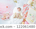 A cute girl baby in a red hakama who looks happy surrounded by spring cherry blossoms at the Hinamatsuri of the first festival 122061480