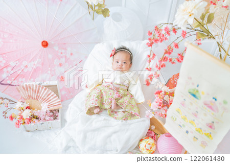 A cute girl baby in a red hakama who looks happy surrounded by spring cherry blossoms at the Hinamatsuri of the first festival A cute girl baby in a red hakama who looks happy surrounded by spring cherry blossoms at the Hinamatsuri of the first festival 122061480
