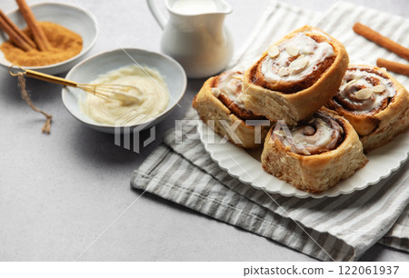 Freshly baked cinnamon rolls topped with icing and almond slivers Freshly baked cinnamon rolls topped with icing and almond slivers 122061937