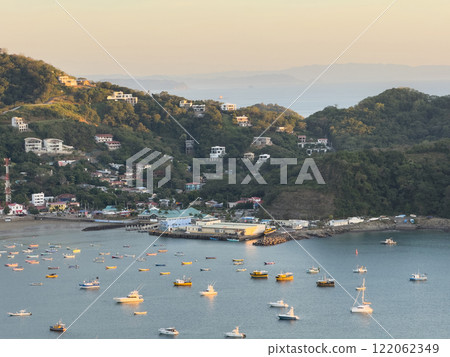 Beautiful coastal view of busy harbor with boats during sunset in seaside town 122062349