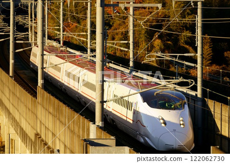 The Shinkansen Tsubame, a six-car 800 series train, runs in the light of the setting sun. 122062730