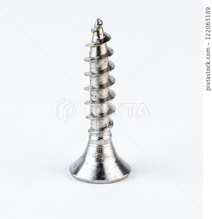 Close-up view of a metallic screw featuring spiral threads. High quality photo Close-up view of a metallic screw featuring spiral threads. High quality photo 122063189