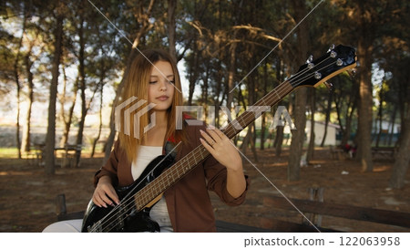 Young Girl Plays Bass Musical Instrument Under Trees In Nature 122063958