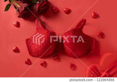 Valentine's day concept with red lace bustier underwear, candy sweets and red roses on red background. Love. View from above. Romantic dating. 122064898