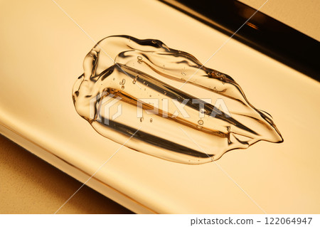 Tasty texture of cosmetic gel on a golden background. Tasty texture of cosmetic gel on a golden background. 122064947