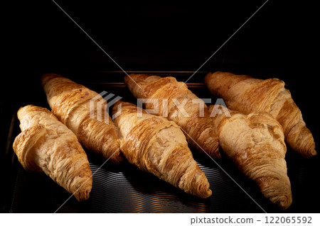 Homemade croissants baking in oven , close-up 122065592