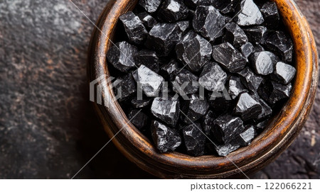 Black mineral rocks displayed in wooden bowl Black mineral rocks displayed in wooden bowl 122066221