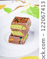 Dubai chocolate with pistachio filling on a white plate. 122067413