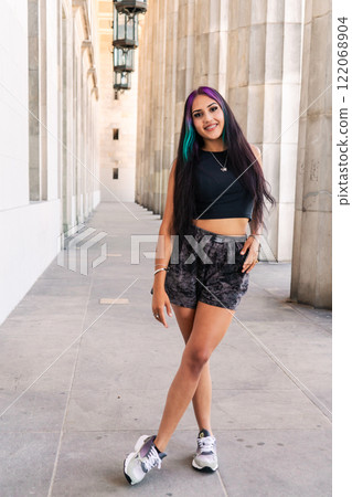 Portrait of a young woman between the columns of a large building. Portrait of a young woman between the columns of a large building. 122068904