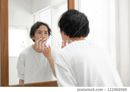 Middle-aged man looking in the mirror 122068980