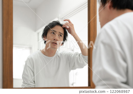 Middle-aged man looking in the mirror 122068987