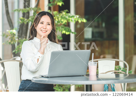 A business woman (nomad worker) doing nomad work on the terrace of a cafe 122069414
