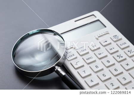黑色背景上的計算器和放大鏡 122069814