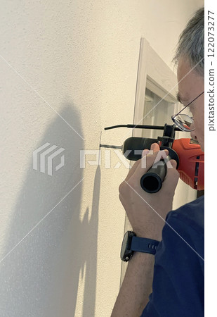 Man use drill with limiter to make hole in wall. Tools and hobbies. Home improvement. 122073277