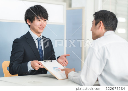 Young Asian businessman serving male customers at reception desk 122073284
