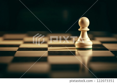 White pawn standing on chessboard in dark room 122073351