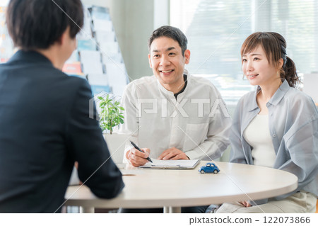 一對夫婦在聆聽，一位商人在陳列室/商務談判空間為客戶提供服務 122073866