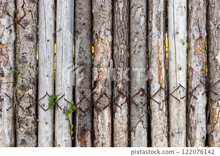 Old grungy dark wooden fence made of slab boards 122076142