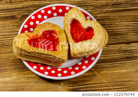 Heart shaped puff cookies with jam on a wooden table. Dessert on Valentine`s Day Heart shaped puff cookies with jam on a wooden table. Dessert on Valentine`s Day 122076744