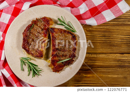 Grilled pork steaks with rosemary on wooden table. Top view 122076771