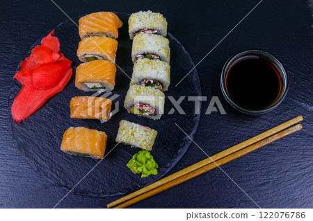 Set of sushi rolls on a black stone slate. Top view 122076786