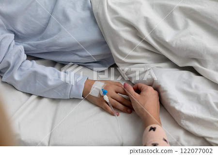 Tender Moment Holding Hands in a Hospital Setting to Offer Comfort and Emotional Support 122077002