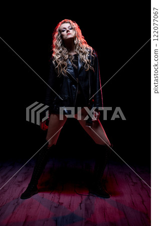 A Confident Model Posing in Dramatic Lighting While Dressed in Fashionable Attire A Confident Model Posing in Dramatic Lighting While Dressed in Fashionable Attire 122077067
