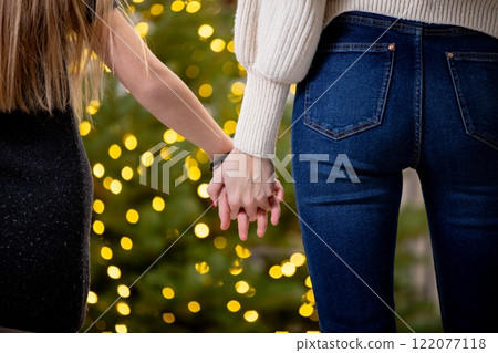 A Couple Holding Hands Together, Surrounded by Soft Lights in the Background at Night 122077118