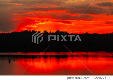 A Beautiful and Stunning Sunset Reflection Over a Calm and Serene Lake During Dusk Evenings A Beautiful and Stunning Sunset Reflection Over a Calm and Serene Lake During Dusk Evenings 122077192