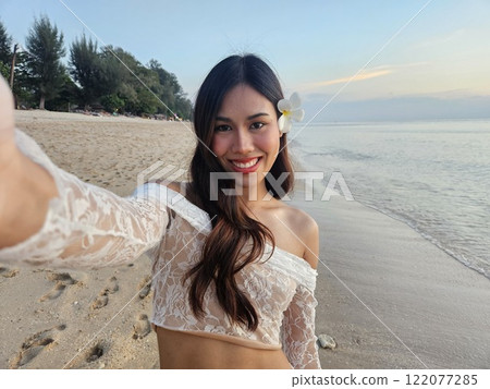 Woman on the beach taking selfie 122077285