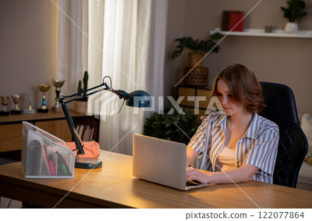 A Focused Professional Effectively Working from Their Home Office with a Laptop Computer 122077864