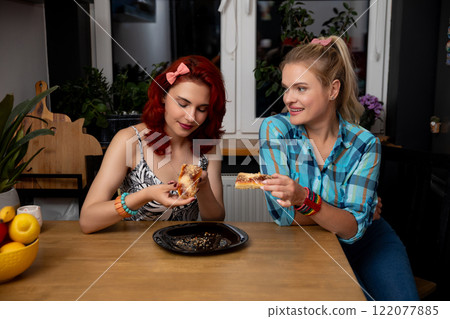 Two Friends Joyfully Enjoying Unique Culinary Delights Within the Comforts of Their Home Two Friends Joyfully Enjoying Unique Culinary Delights Within the Comforts of Their Home 122077885